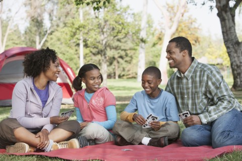 Family playing cards at campsite