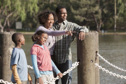 Family overlooking rural lake on dock