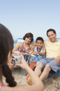 Family taking pictures together on beach