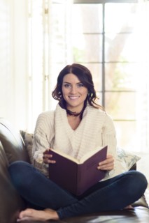 Caucasian woman sitting on sofa reading book