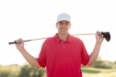 Portrait of Hispanic golfer holding golf club on shoulders