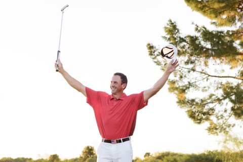 Hispanic golfer waving on golf course