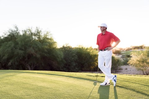Hispanic golfer waiting on golf course