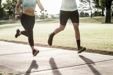 Couple running on path in park