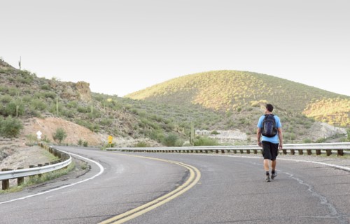 Hispanic man hiking on winding street