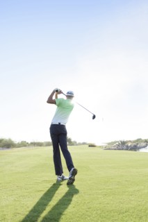 Caucasian man teeing off on golf course