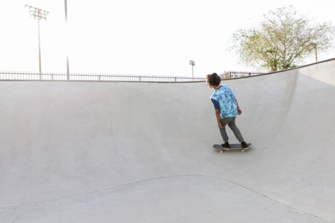 Hispanic man riding skateboard on ramp