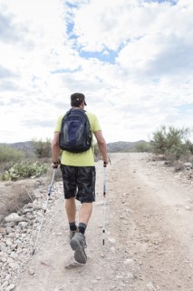 Hispanic man hiking on rocky path in desert