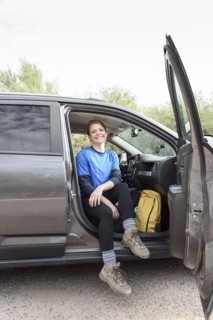 Portrait of Caucasian woman sitting in car with door open