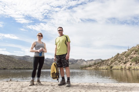 Portrait of smiling hikers standing at lake