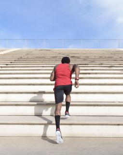 African American man running on bleachers