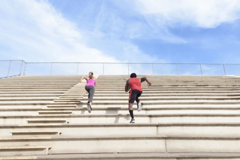 Man and woman running on bleachers