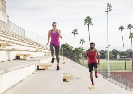 Man and woman running on bleachers