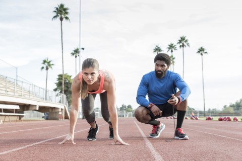 Man timing woman on track in starting position