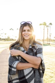Smiling Hispanic woman wearing plaid poncho