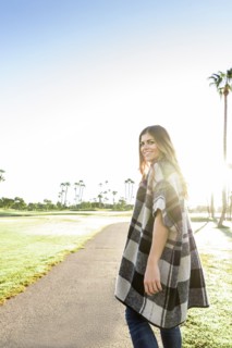 Hispanic woman wearing poncho walking on path