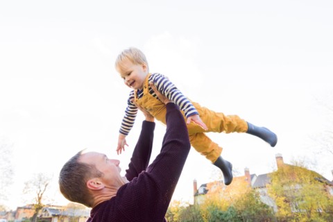 Caucasian father lifting son