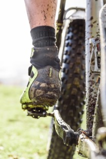 Leg of Caucasian man splattered in mud riding bicycle
