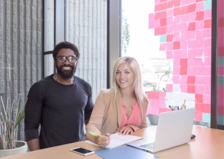 Creative business people posing with laptop at table