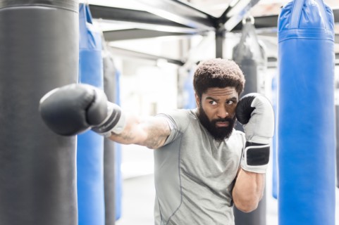 Portrait of Black man wearing boxing gloves in gymnasium