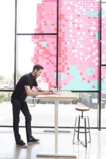 Caucasian man using a laptop at standing workstation