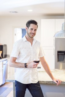 Smiling Caucasian man drinking red wine