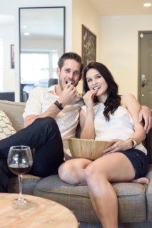 Smiling Caucasian couple sitting on sofa watching television