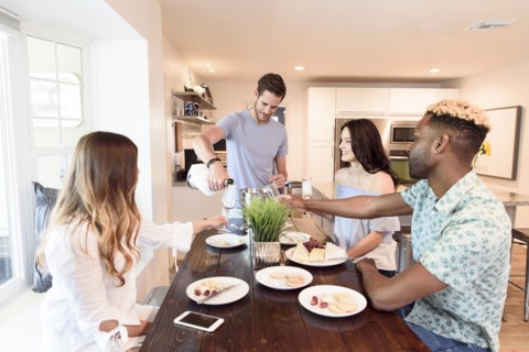 Man pouring champagne for friends at table