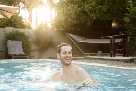 Smiling Caucasian man relaxing in swimming pool