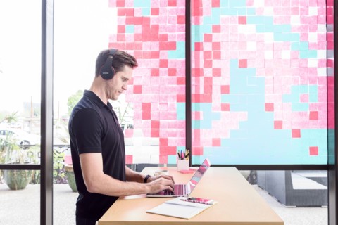 Caucasian man typing on laptop and listening to headphones