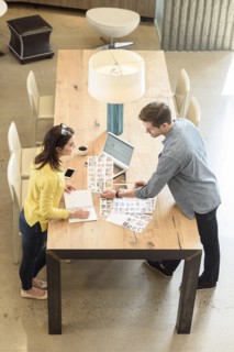 Caucasian man and woman examining photographs at table