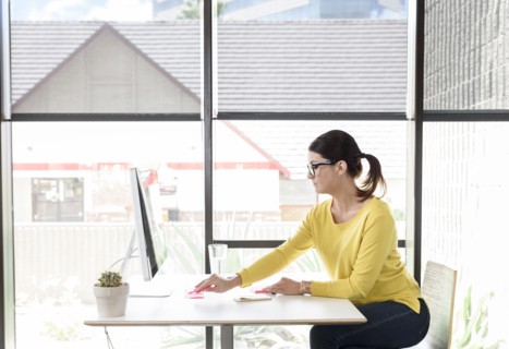 Caucasian woman writing on adhesive notes at desk