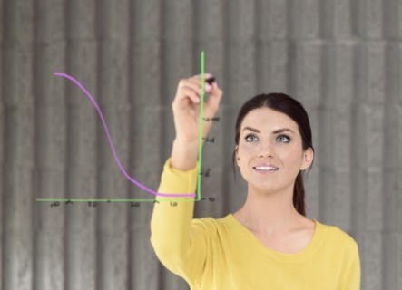 Caucasian woman drawing chart on glass wall
