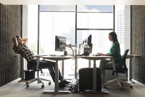 Caucasian man and woman using computers in office