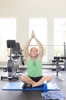 Caucasian man practicing yoga in gymnasium
