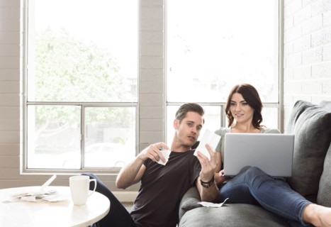 Caucasian couple using laptop on sofa