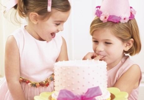 Young girls picking at a birthday cake