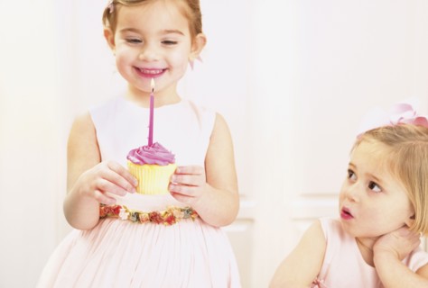 Young girl holding a birthday cupcake