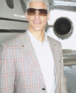 Close up of middle-aged man standing in front of airplane
