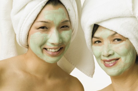 Young woman and her mother smiling for the camera in face masks