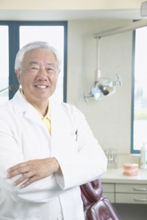 Senior Asian male dentist smiling