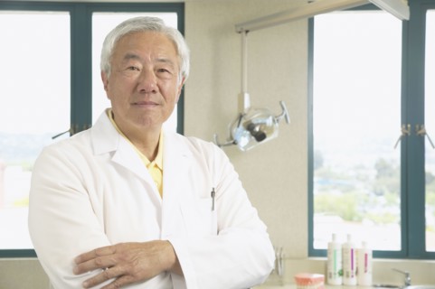 Senior Asian male dentist in office