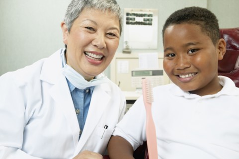 Senior Asian female dentist with young male patient