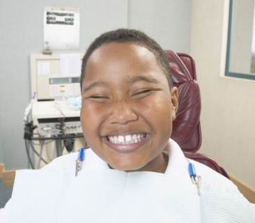 African boy smiling in dentist's chair