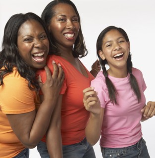 African mother and daughters laughing and hugging