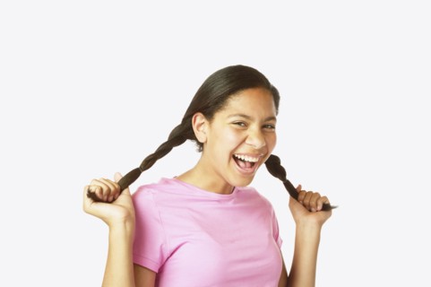 Studio shot of Hispanic girl holding her pigtails