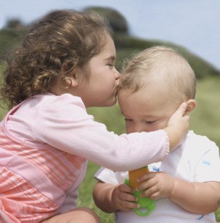 Hispanic girl kissing baby