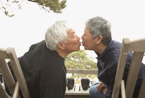 Senior Asian couple kissing outdoors