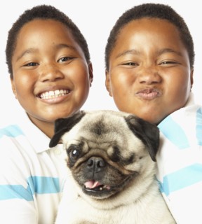 Young African twin brothers holding small dog