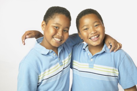 Young African twin brothers hugging and smiling